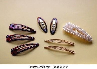 Tortoise Shell, Golden And Pearl Hair Accessories On Yellow Background. Selective Focus.