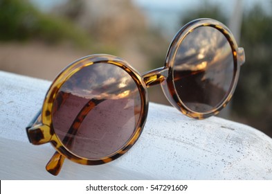 Tortoiseshell sunglasses with reflection of sunset at the beach, Airey's Inlet, Victoria, Australia