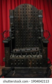 Torture Chair On Red Background.