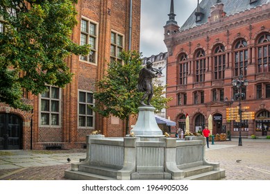 Torun, Poland - 09.07.2020: A Statue Of A Rafter Surrounded By Eight Frogs. The Legend Of The Poor Raftsman. Situated On The Old Town Square. The Violin Player. Sculpture Unveiled In 1914.