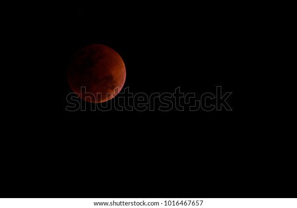 Total lunar eclipse, beautiful blood moon on\
dark night, Thailand.