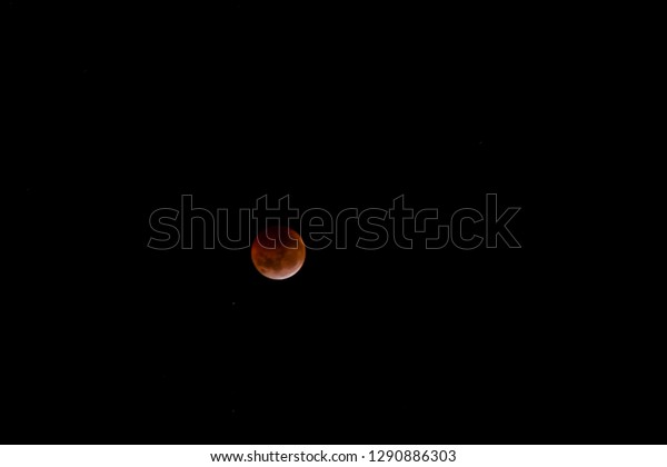 Total\
lunar eclipse. The bloody moon over a dark\
sky