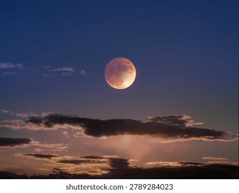 Total Lunar Eclipse. Moon in the evening sky above the clouds. Astronomical phenomenon.