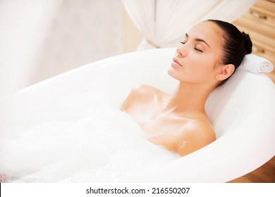 Total relaxation. Attractive young woman keeping eyes closed while enjoying luxurious bath 