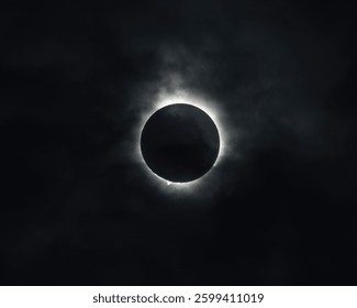 The Total Solar Eclipse creates a ring of light around the moon on April 8, 2024. Slight cloud cover makes the ring more visible and gives it a cool spooky effect.