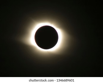 total solar eclipse, dark silhouette of the Moon with visible solar corona on the black sky