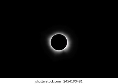 Total solar eclipse during totality near Mount Ida, Arkansas on April 8, 2024.  Solar prominences can be seen at the edge of the black moon with the corona emanating out