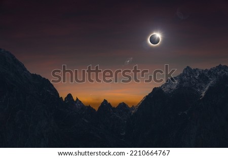 Total solar eclipse over high mountains, amazing dark mysterious scientific image. During eclipse disk of Sun is completely covered by Moon.