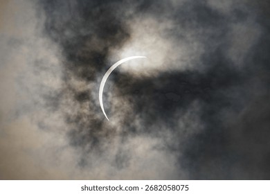 Total Solar Eclipse through swirling clouds and fog at Garner State Park Texas.  Great American Mexican Eclipse GAME 2024.  Red solar flares and prominances are abundant.