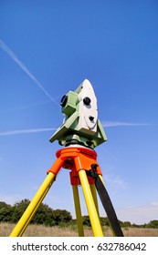 Total station with blue sky in the background. Survey Instrument geodetic device, total station set in the field. Total station surveying and measuring engineering equipment at workplace.
