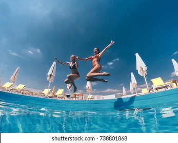 Totally Free. Two Attractive Young Women In Bikini Jumping In The Pool Together