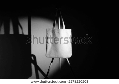 Tote Bag branding mockup template on a metal hanger with deep shadows, real photo. Blank isolated to place your design. 