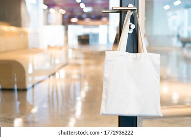 Tote Bag Canvas Fabric For Mockup Blank Template, Hanging On A Doorknob In The Meeting Room In The Office With Blur Background.