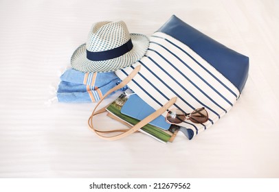 Tote Bag Full of Summer Beach Essentials , Hat, Towels, Sunglasses, Tablet - Powered by Shutterstock