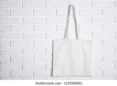 Tote bag hanging on brick wall. Mock up for design - Powered by Shutterstock