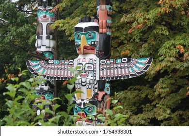 Totem Pole Of Eagle Owl Wolf At Stanley Park In British Columbia Vancouver City. Indigenous Native American Art And Craft.