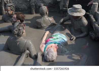 Totumo Volcano, Santa Catalina, Colombia, March 3, 2019. White-Skinned Woman About To Be Dunked In A Volcanic Mud Bath