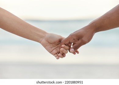 Touch, love and support with interracial couple holding hands in a committed, loving and close relationship. Closeup hands of man and woman enjoying beach travel, sea vacation or holiday and romance - Powered by Shutterstock