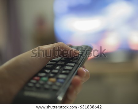 touch the remote human hand changes the channels on the TV remote control