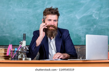 In Touch With School. School Principal Or Teacher Calling Parents To Report About Exam Results. School Teacher Cares About Communication With Parents. Man With Beard Talk Phone Classroom Background.