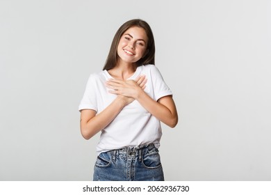 Touched Happy Young Woman Smiling, Holding Hands On Chest, Feeling Thankful