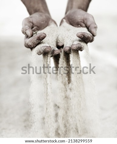 Touching the beach. Shot of a man with a handful of sand falling through his fingers.
