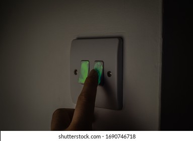 Touching Light Switch Glowing Under UV Light Visualisation Exposing Germs And Viruses Spreading.