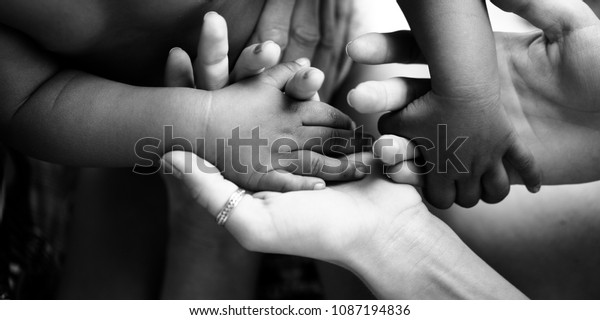 Touching moment, touch of the hand of a small\
child and an adult woman. Mother and child, adoptive children,\
adoption. A white woman and a dark skinned child. Interracial\
relations, multiracial\
family