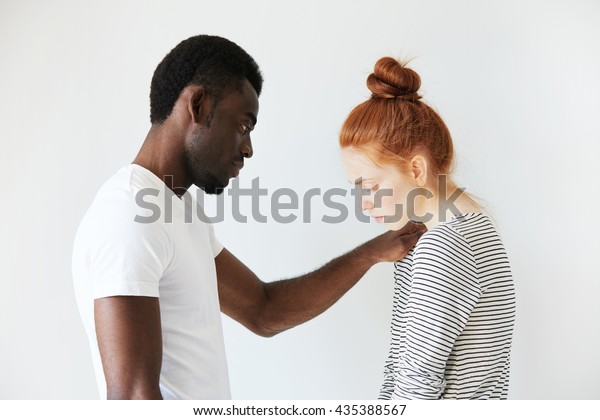 若い赤毛の女の子を慰めるアフリカ系アメリカ人男性の感動的なシーン 彼は彼女の失敗に同情し 困った時に彼女を支えるために彼女の肩に腕を置いた 白人の女の子は悲しみのあまり見下ろしている の写真素材 今すぐ編集