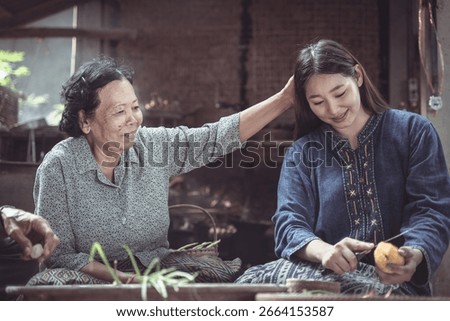 A touching scene featuring an elder and a young woman sharing laughter and joy as they prepare fruit together in a traditional setting, highlighting familial love.
