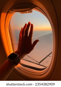 Touching the sky though the window of a plane