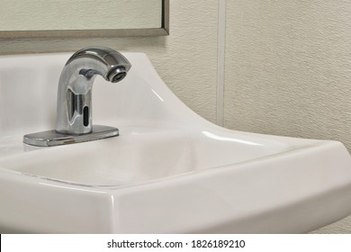 Touchless Automated Bathroom Faucet And Sink, Angled View Showing Partial Mirror And Walls.