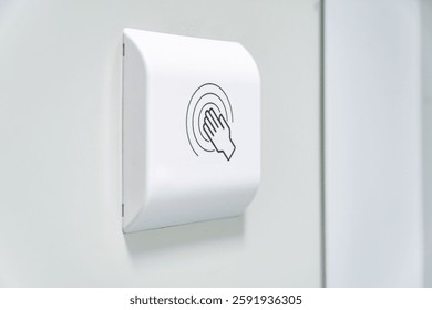 Touchless hand sensor switch on a white wall