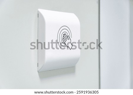 Touchless hand sensor switch on a white wall