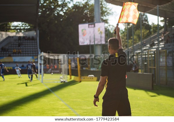 Touchline referee with reised flag during the\
soccer match.