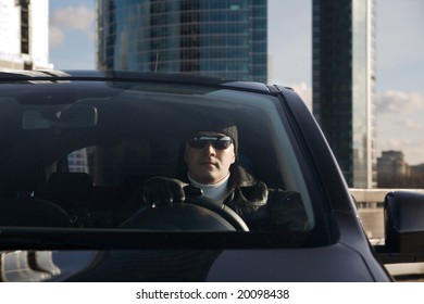 Tough Guy In Leather Jacket In His Car And Skyscrapers At Background