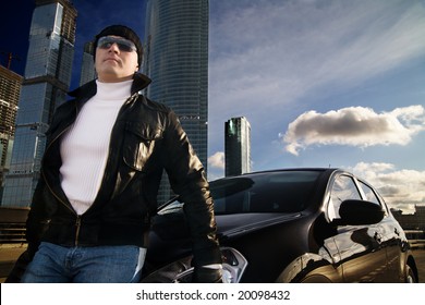 Tough Guy In Leather Jacket Near His Car And Skyscrapers At Background