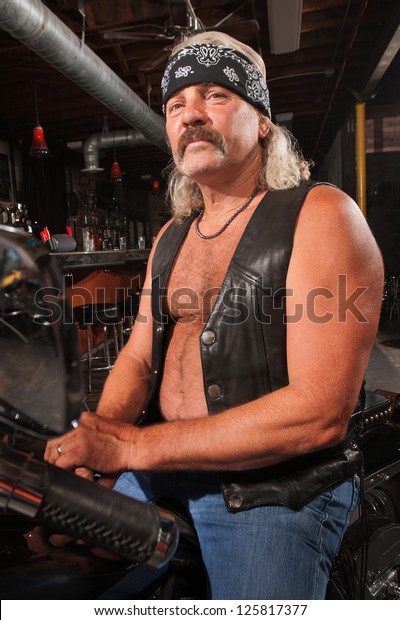 Tough middle aged\
man on motorcycle in bar