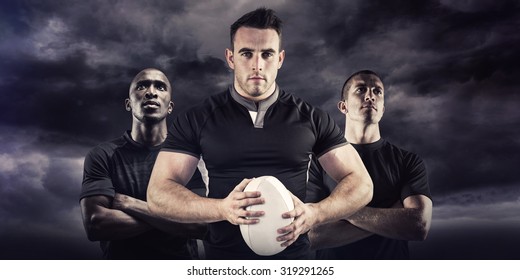 Tough rugby player looking at camera against blue sky - Powered by Shutterstock