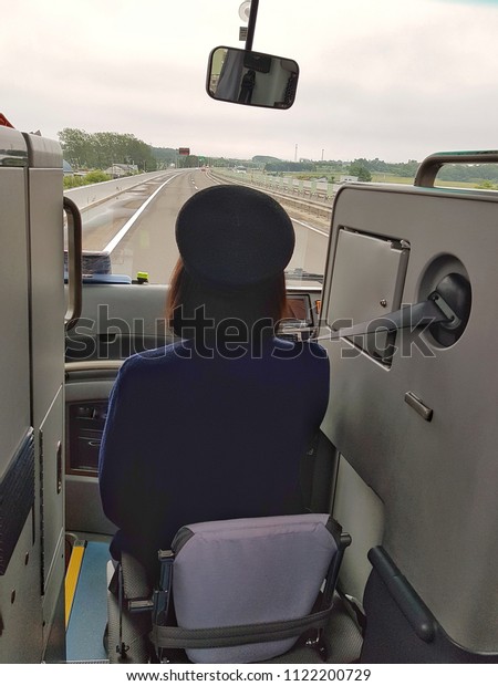 A tour guide sitting in front of the bus while\
driving on express way