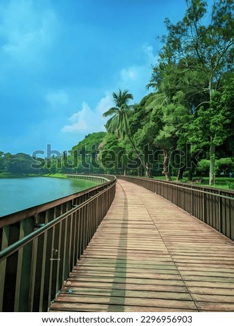 Tour and travels in a beautiful place. Wood bridge over the blue sea sky and green trees beside
