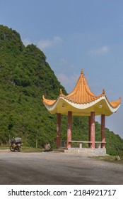 A Touring Motorcycle With Heavy Baggage Resting Beside A Yellow Asian Style Pavilion On The Halfway Up The Mountain