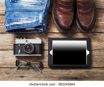 Tourism concept - set of stuff with camera and other travel things on wooden table background