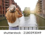 Tourism in Germany. Beautiful young woman visiting Speicherstadt district in the port of Hamburg, Germany. UNESCO World Heritage Site.
