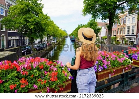 Tourism in Holland. Back view of beautiful fashion girl between flower pots in The Hague, Netherlands.