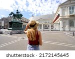 Tourism in Holland. Back view of young tourist woman visiting Noordeinde Palace in The Hague, Netherlands.