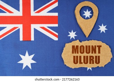 Tourism And Industry Concept. The Flag Of Australia Has A Geolocation Symbol And A Sign With The Inscription - Mount Uluru