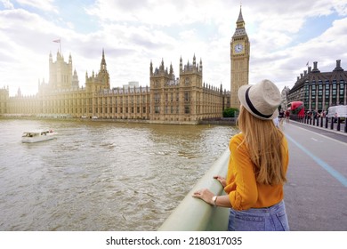 Tourism in London. Back view of traveler girl enjoying sight of Westminster palace and bridge on Thames with famous Big Ben tower in London, UK. - Shutterstock ID 2180317035