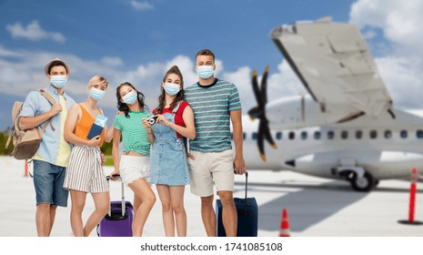 Tourism, Pandemic And Health Care Concept - Group Of Friends Wearing Face Protective Medical Mask For Protection From Virus Disease With Travel Bags, Air Tickets And Camera Over Airplane Background