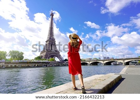 Tourism in Paris, France. Back view of young woman visiting the city of Paris with Eiffel Tower and Seine River.